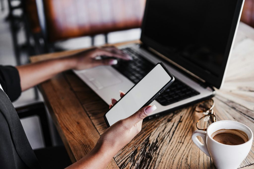 unrecognizable woman in cafe working on laptop and mobile phone.Business and tech